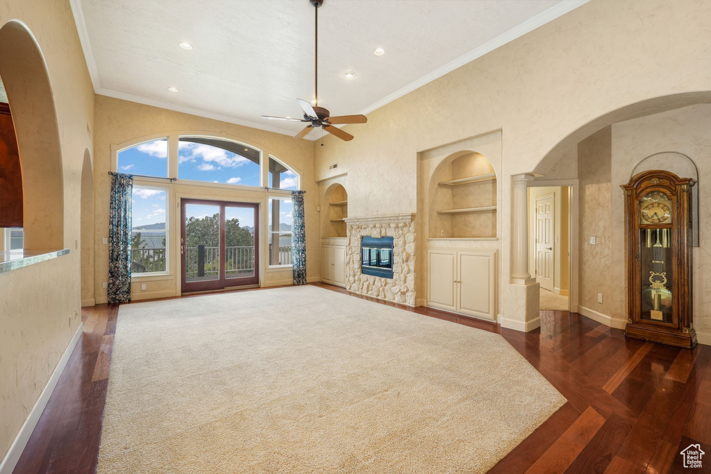 Unfurnished living room with built in shelves, ceiling fan, dark wood-style flooring, recessed lighting, and a fireplace