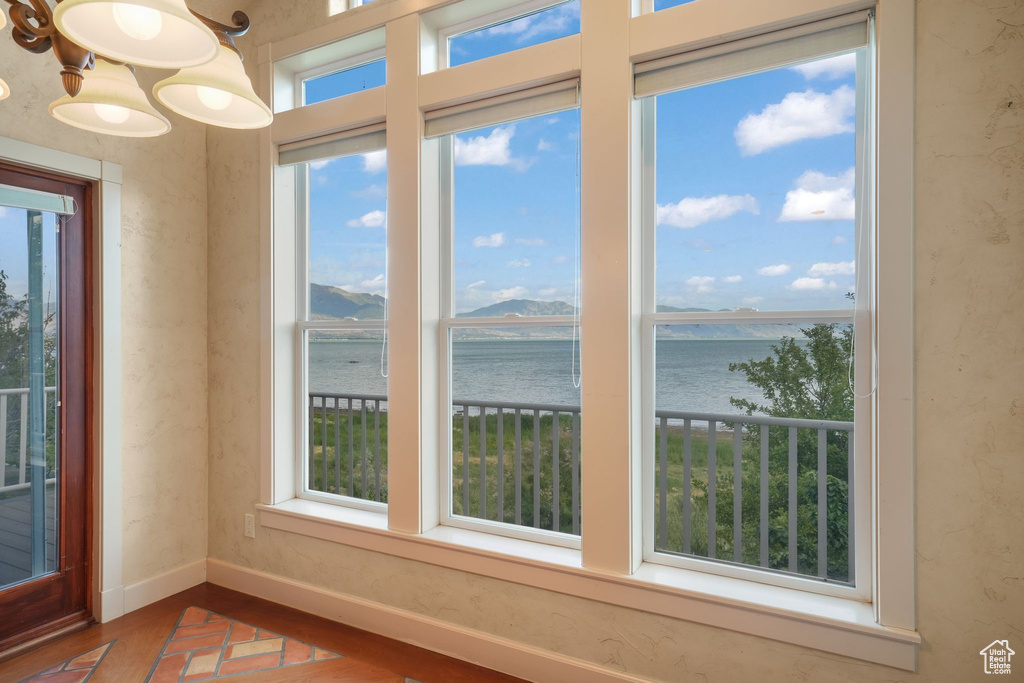 Spare room with a water view and wood finished floors