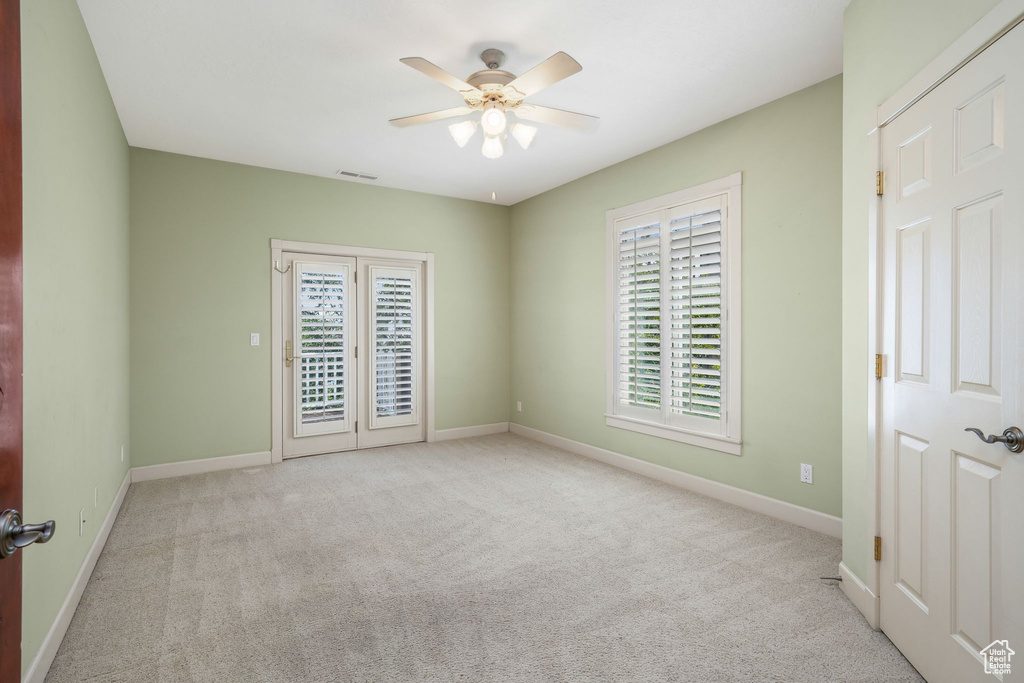 Empty room with a ceiling fan and carpet floors