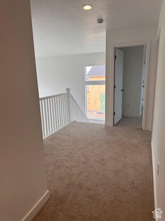 Hall featuring carpet, a textured ceiling, and recessed lighting