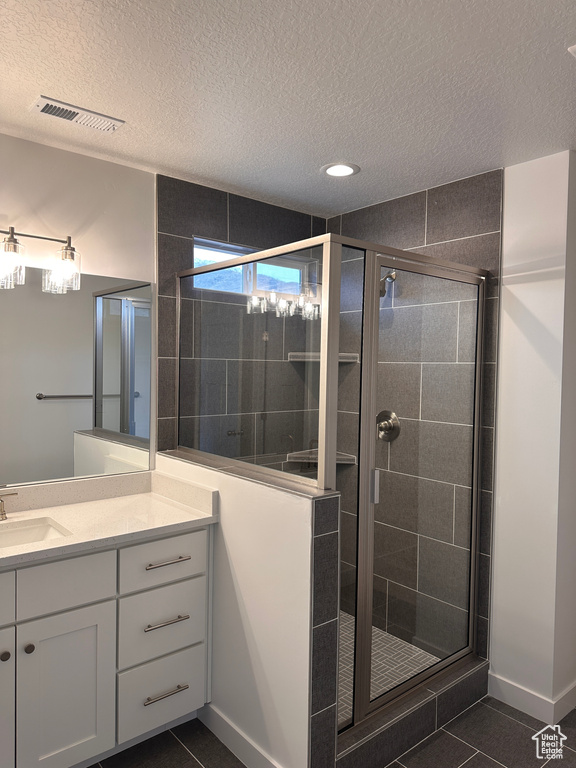 Full bath with a textured ceiling, vanity, a stall shower, tile patterned floors, and recessed lighting