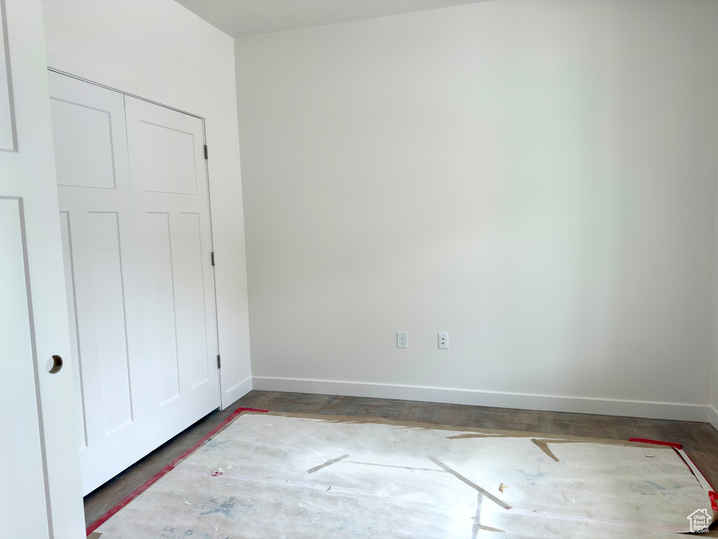 Unfurnished bedroom featuring a closet and wood finished floors