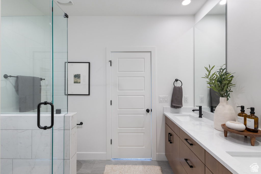 Full bath with double vanity and a stall shower