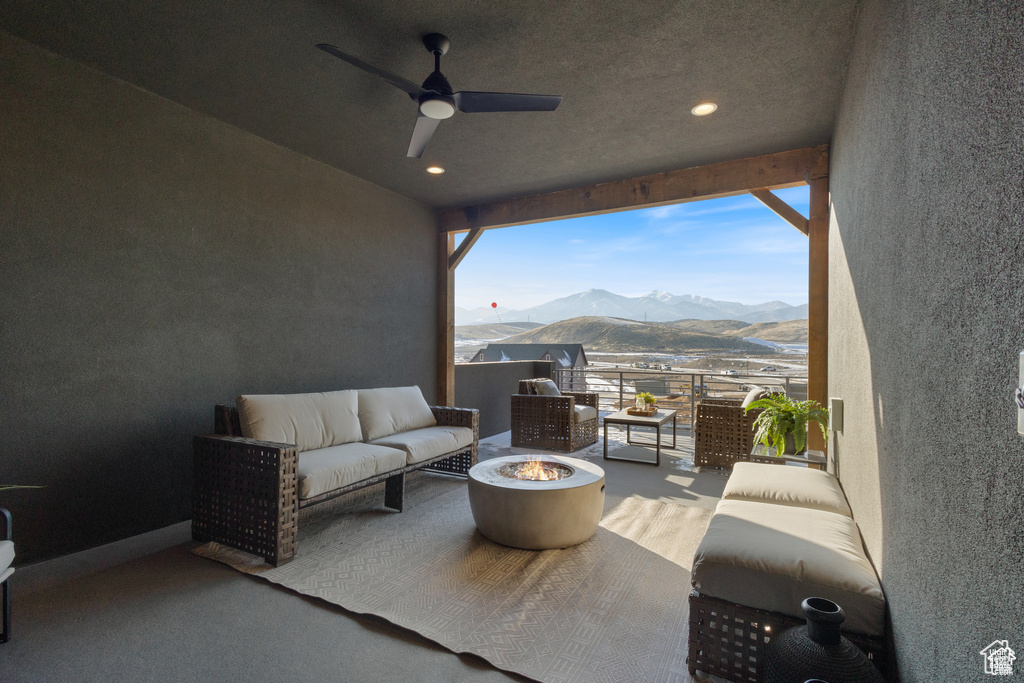 View of patio featuring an outdoor living space with a fire pit, a mountain view, and a ceiling fan
