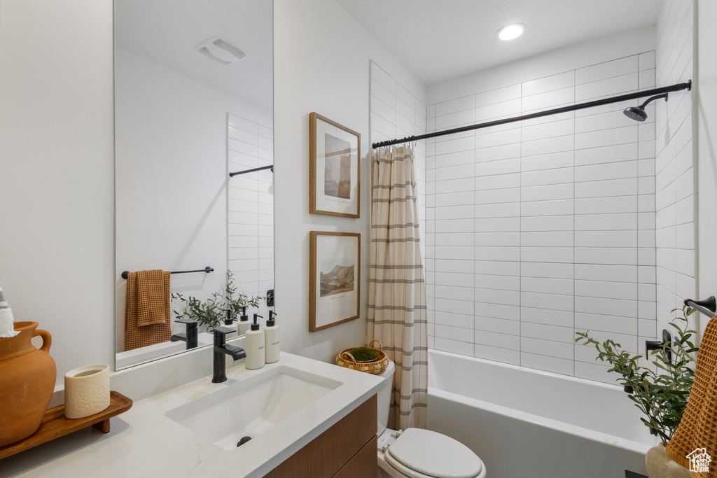 Bathroom with vanity, shower / bath combo, and recessed lighting