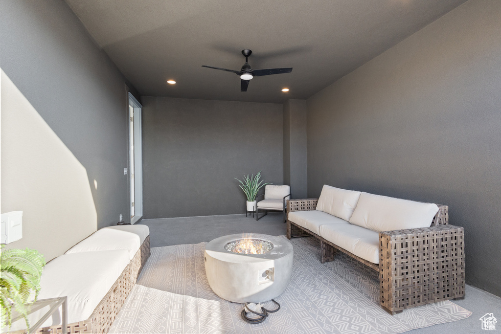 View of patio featuring an outdoor living space with a fire pit and a ceiling fan