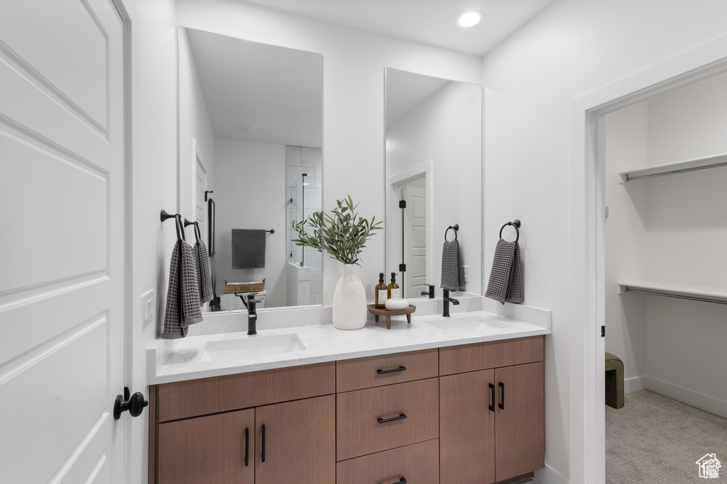 Full bath with double vanity, walk in shower, and recessed lighting
