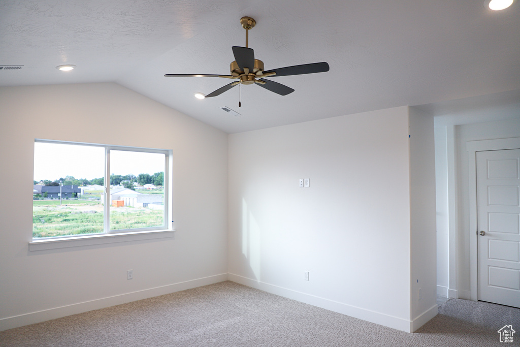 Spare room featuring light colored carpet, ceiling fan, lofted ceiling, and recessed lighting
