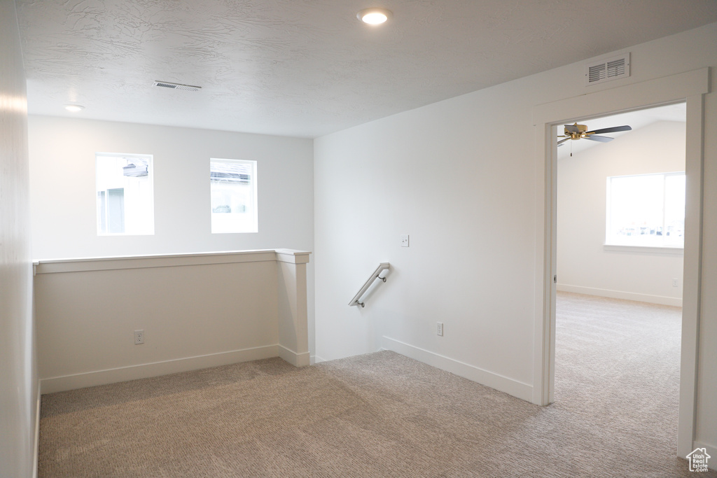 Carpeted spare room with a ceiling fan and recessed lighting