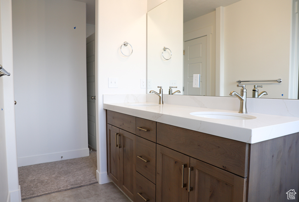 Bathroom with double vanity and baseboards