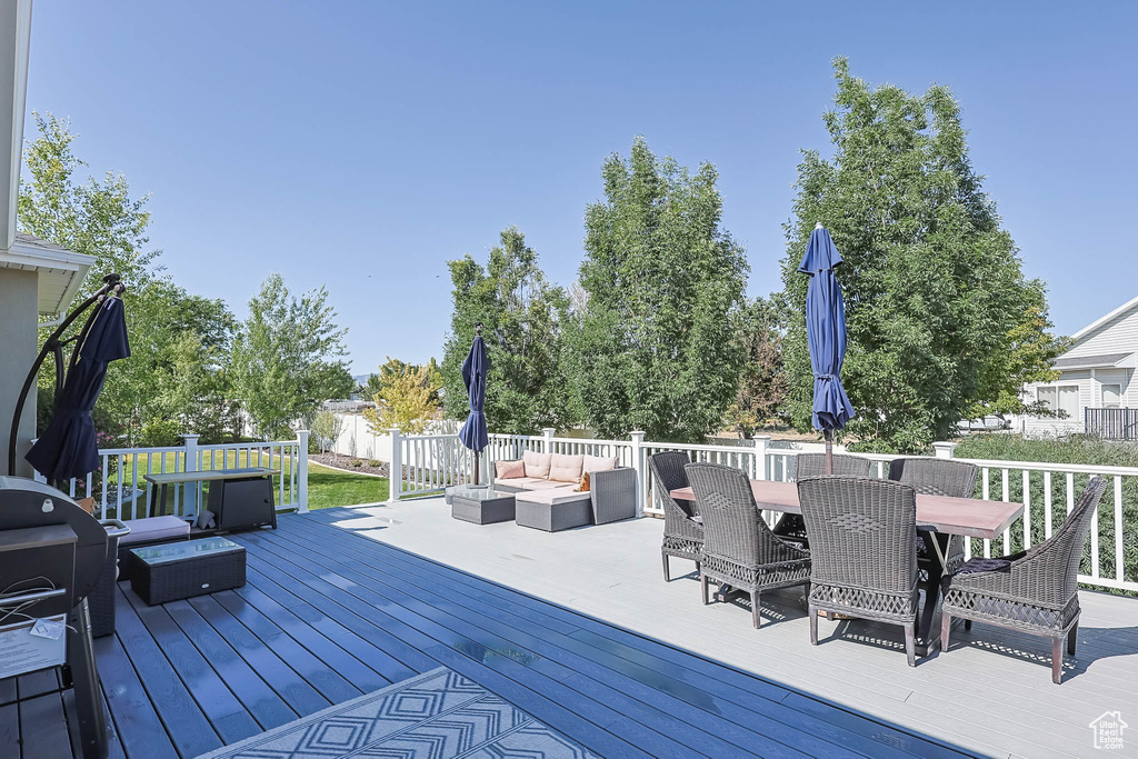 Wooden deck with an outdoor hangout area and outdoor dining space