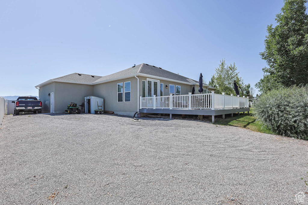 Rear view of house with a deck and stucco siding