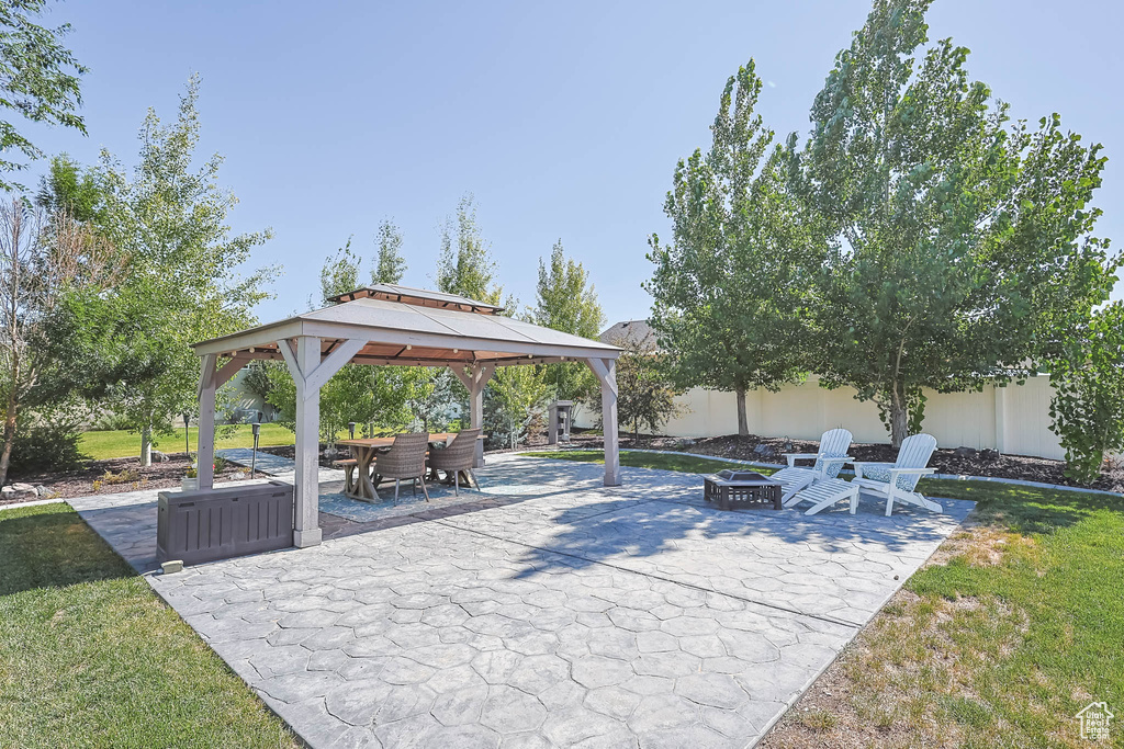 View of patio featuring a fire pit and a gazebo