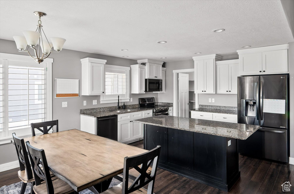 Kitchen with black appliances, a center island, dark wood-type flooring, white cabinets, and recessed lighting