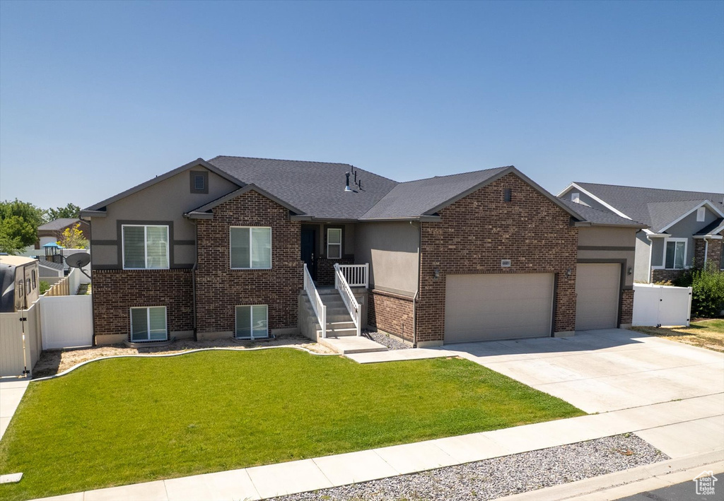 Ranch-style home featuring concrete driveway, brick siding, a garage, and stucco siding