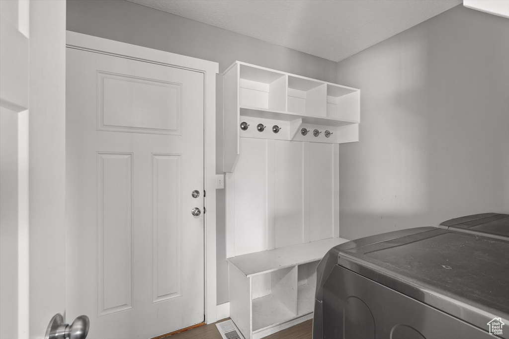 Mudroom with independent washer and dryer and dark wood finished floors