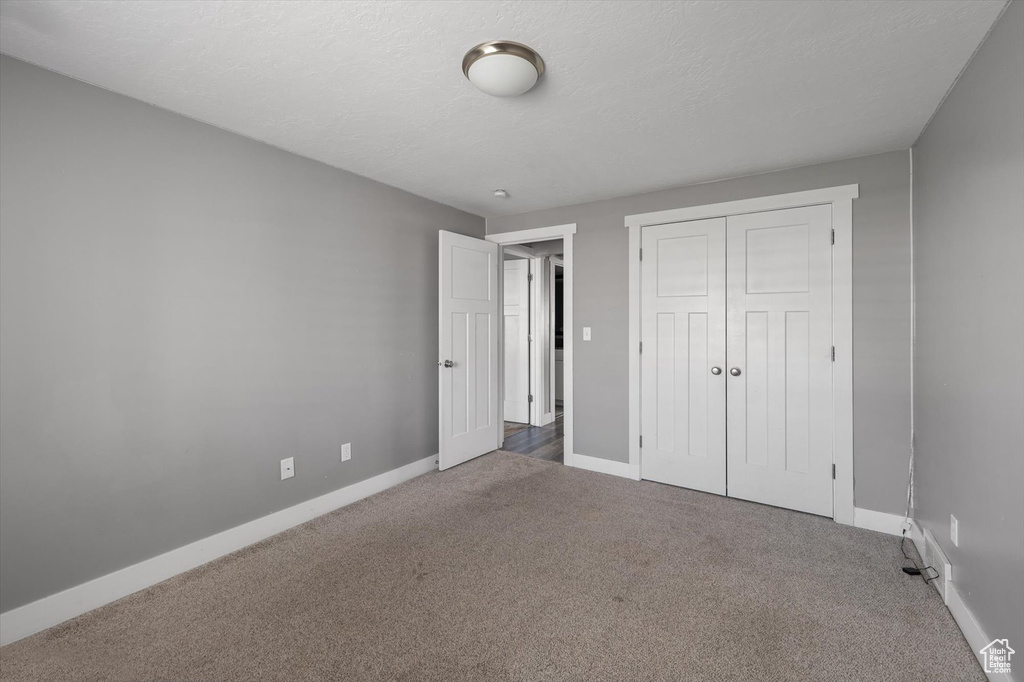 Unfurnished bedroom with carpet flooring and a closet