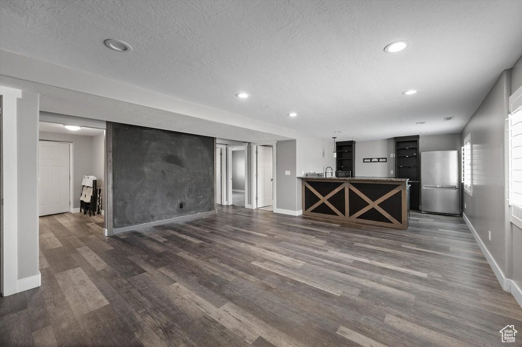 Unfurnished living room with recessed lighting, dark wood-type flooring, and a textured ceiling