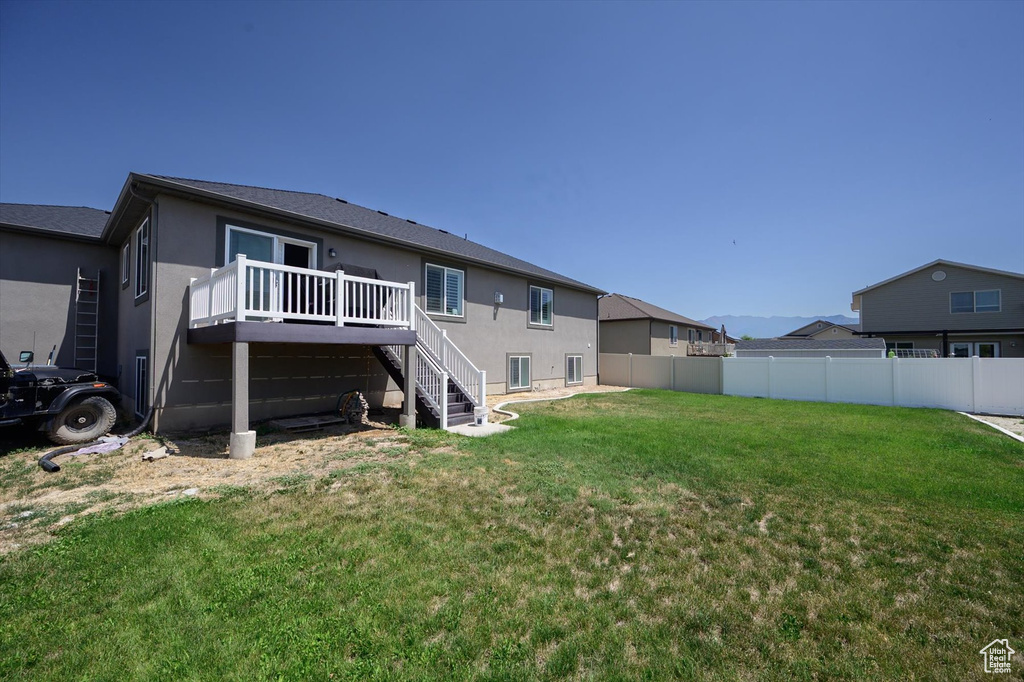 Rear view of house featuring stairway, a deck, and stucco siding