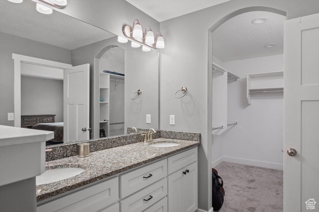 Full bathroom with double vanity and a spacious closet