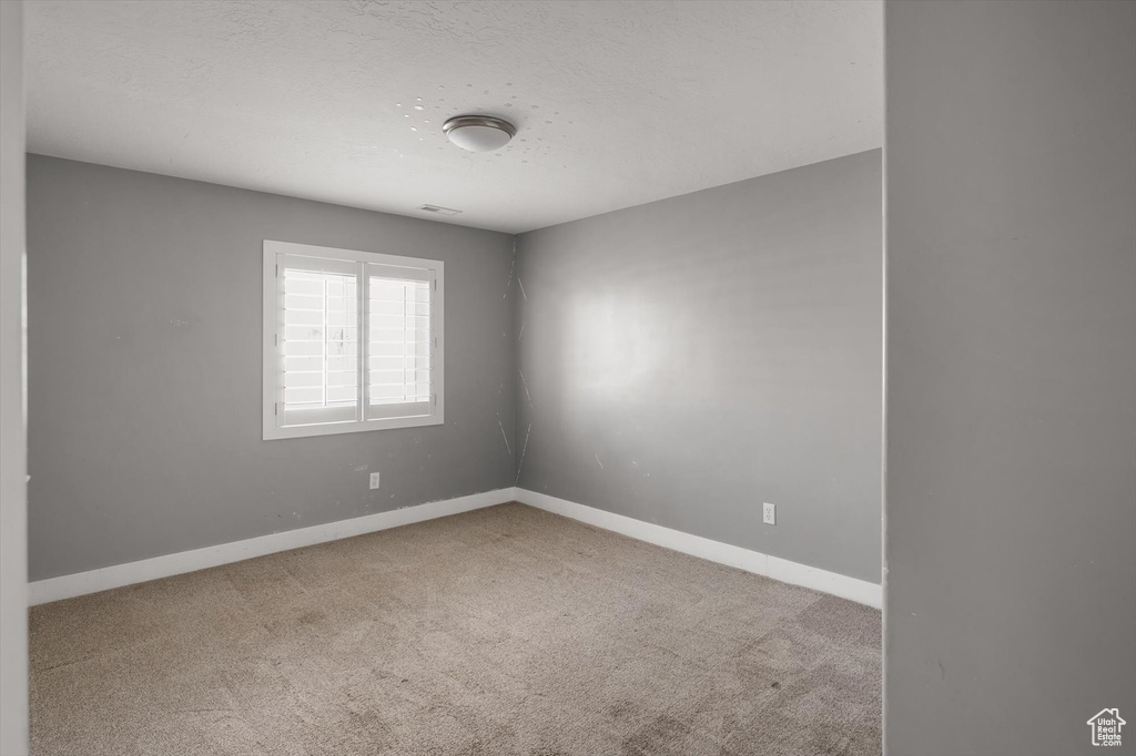 Spare room with carpet and a textured ceiling