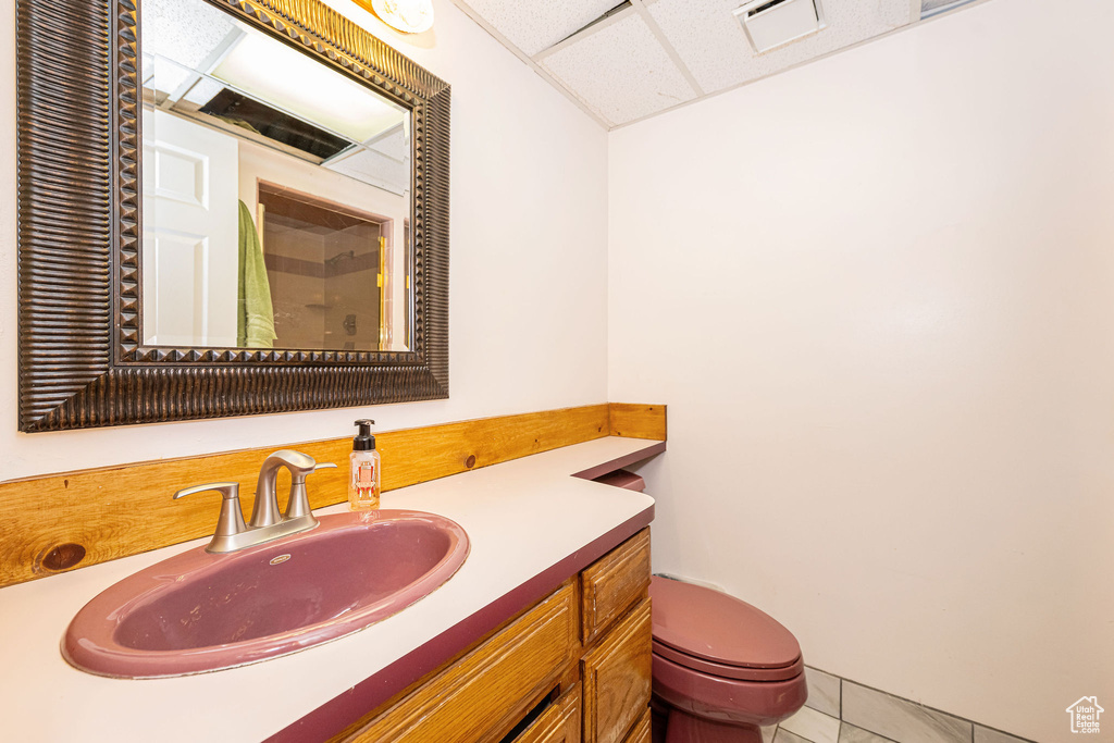 Bathroom featuring vanity, a drop ceiling, a shower with curtain, and tile patterned floors