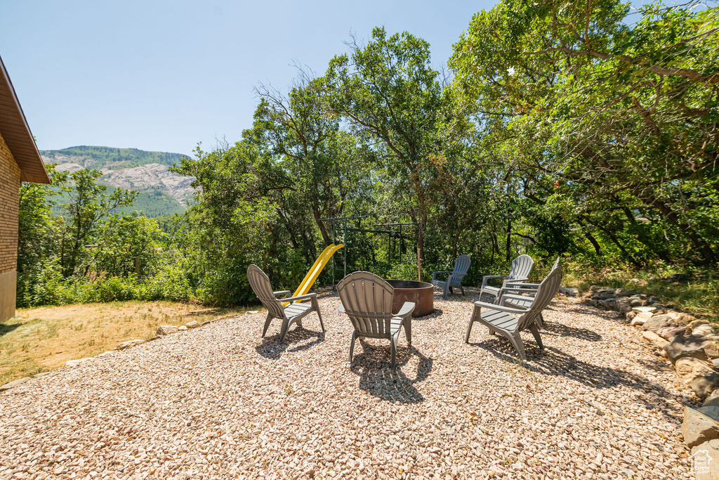 View of patio with an outdoor fire pit and a mountain view
