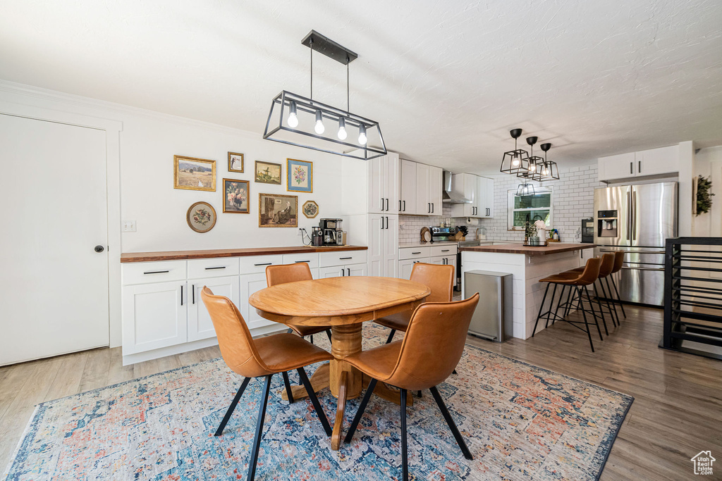 Dining area with light wood finished floors and a chandelier