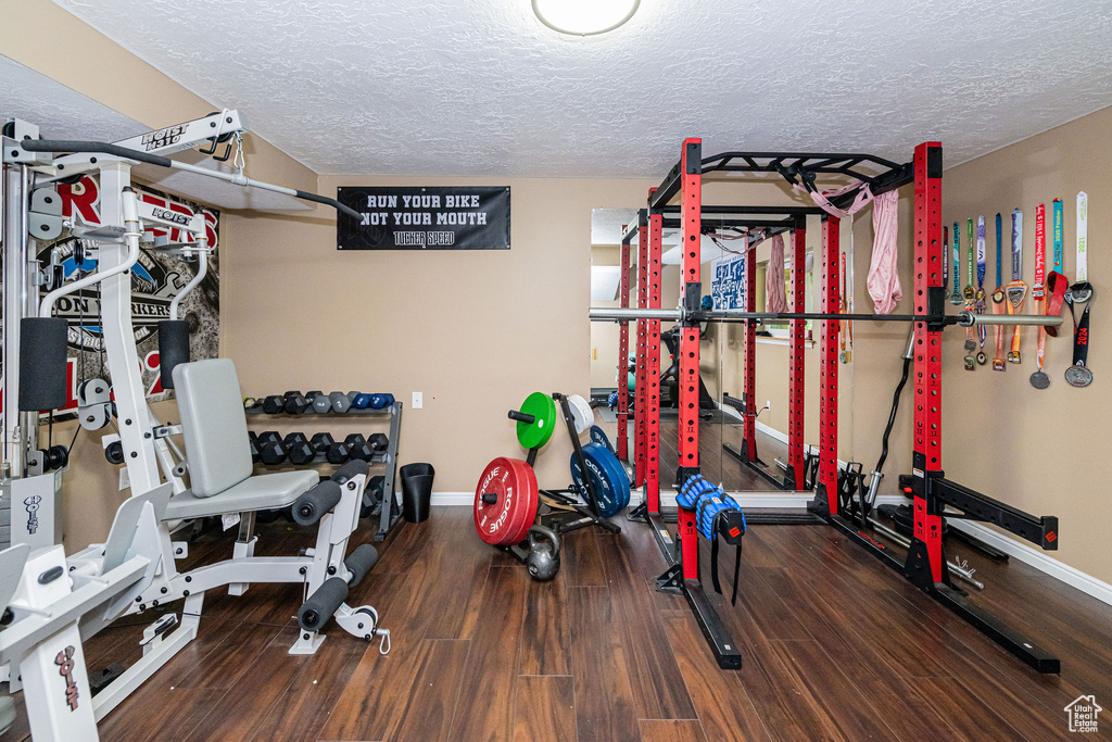 Workout room featuring a textured ceiling and wood finished floors