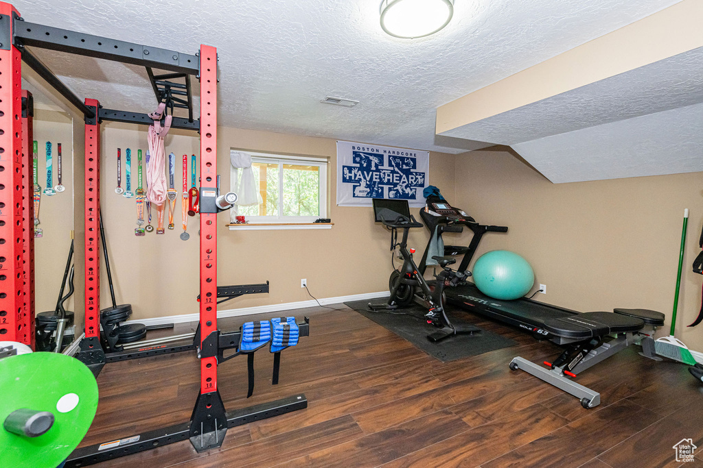 Exercise room featuring a textured ceiling and wood finished floors
