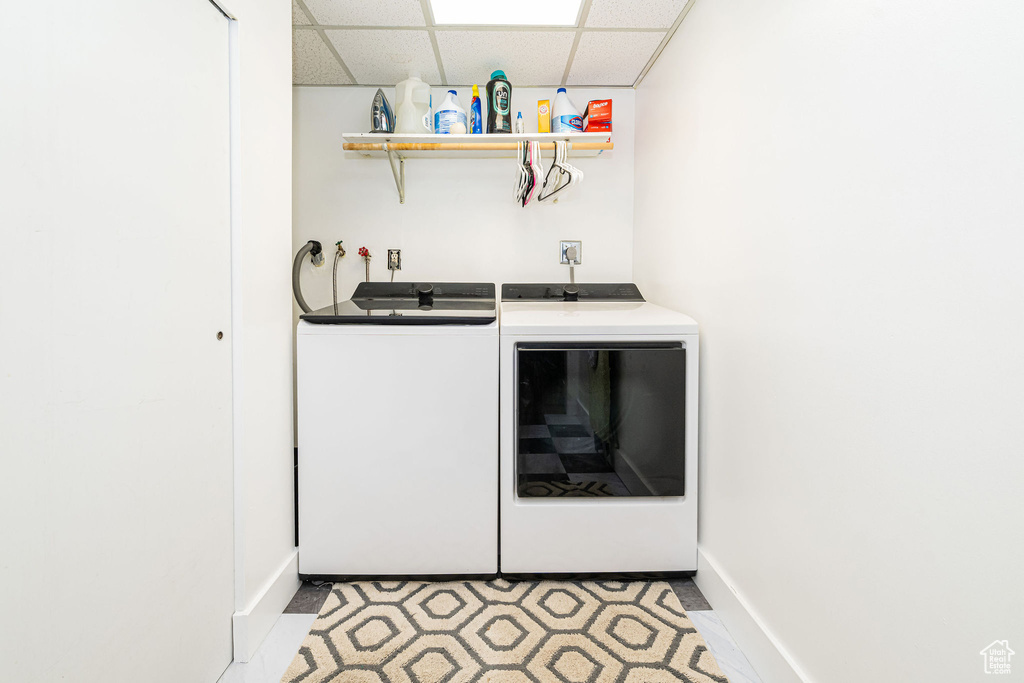 Washroom featuring washing machine and clothes dryer and bar with sink