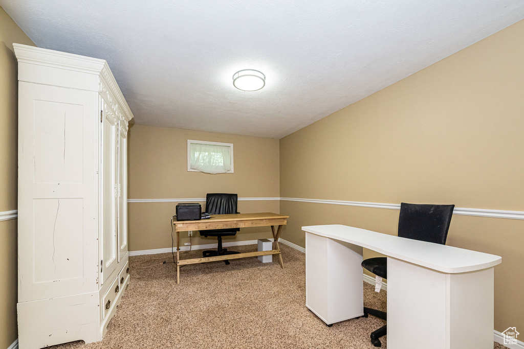 Office space with light colored carpet and baseboards
