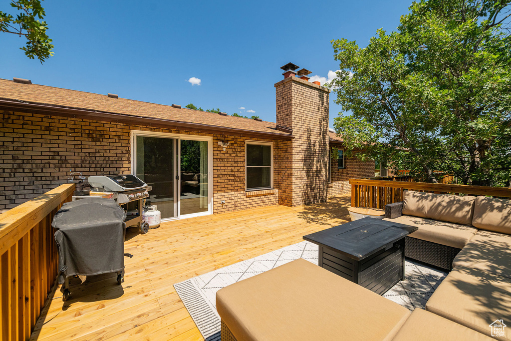 Wooden deck with an outdoor hangout area and area for grilling