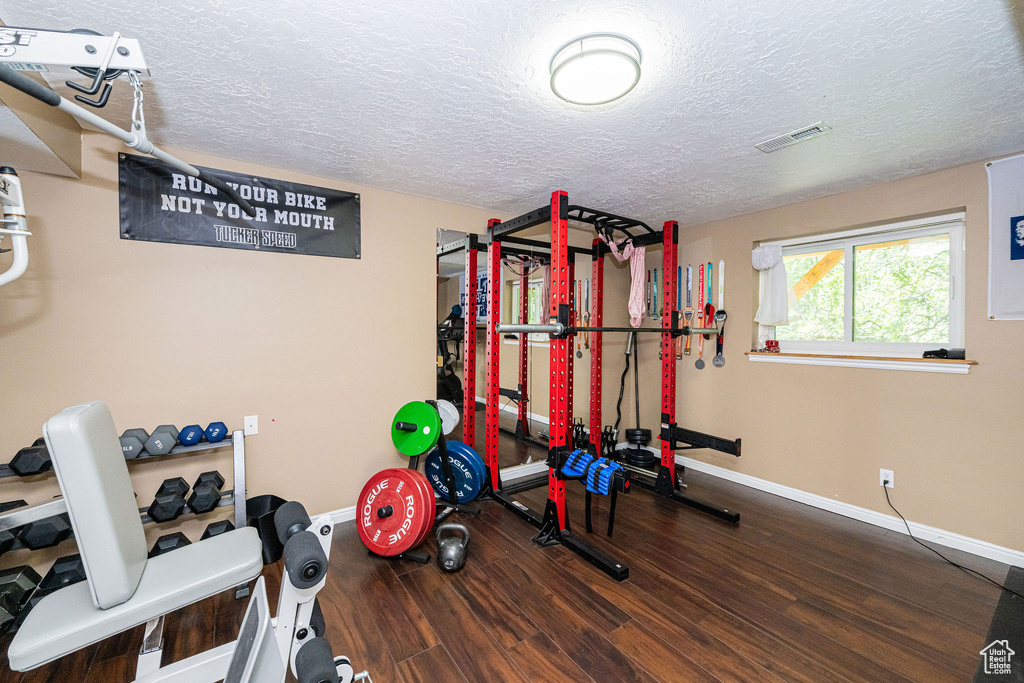 Workout room featuring wood finished floors and a textured ceiling