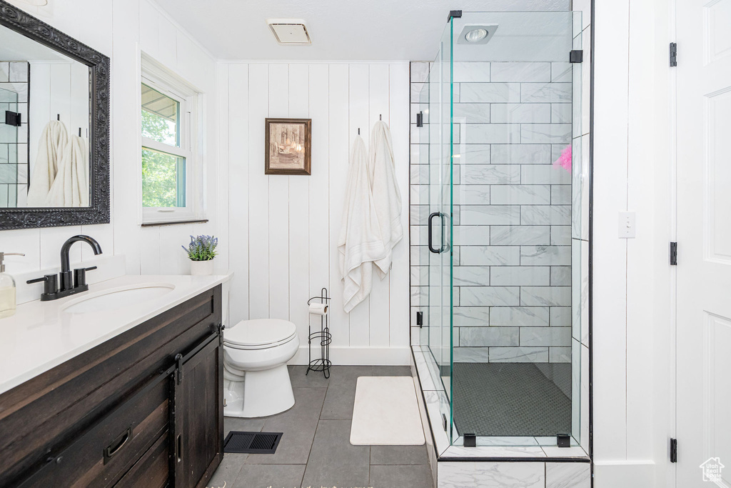 Full bathroom featuring vanity, a shower stall, and tile patterned flooring