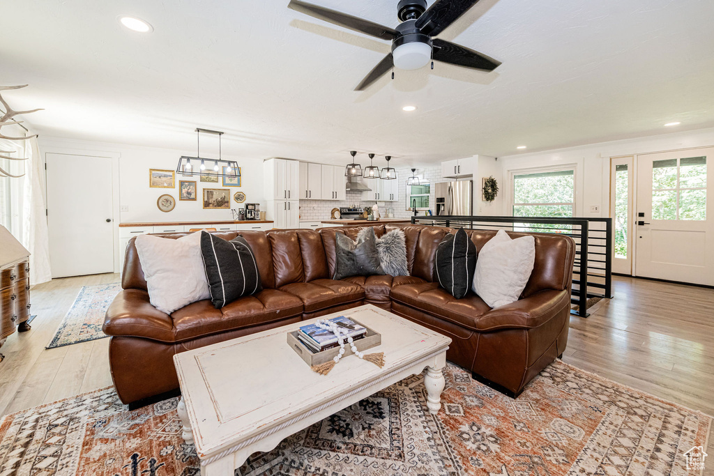 Living area featuring ceiling fan, light wood-style floors, and recessed lighting