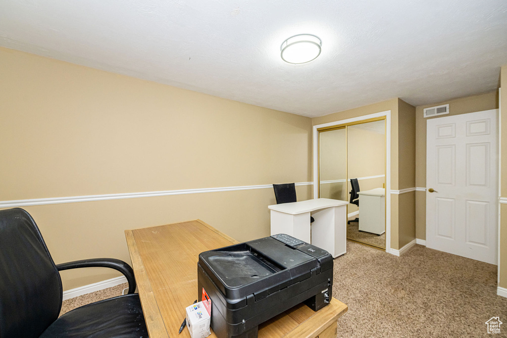 Carpeted office space featuring baseboards