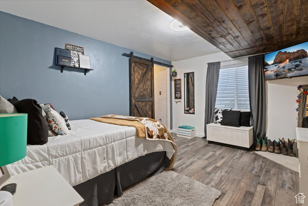 Bedroom featuring a barn door and hardwood / wood-style floors