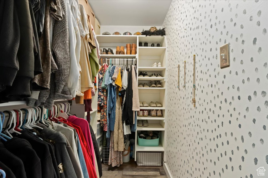 Walk in closet with wood finished floors