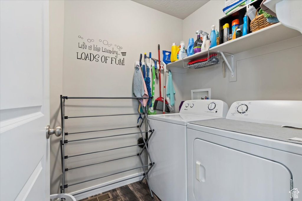 Laundry area with washer and dryer and wood finished floors