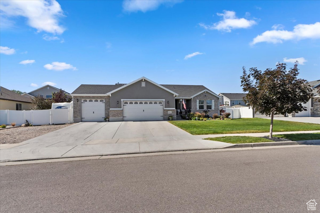 Single story home with a garage, driveway, and stone siding