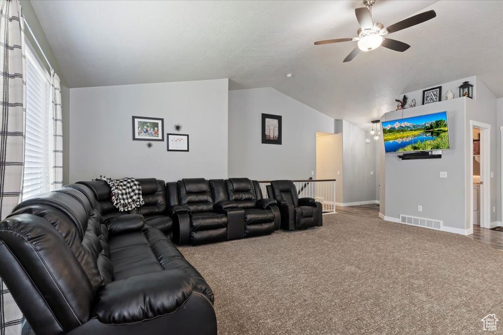 Living area with lofted ceiling, a ceiling fan, and carpet floors