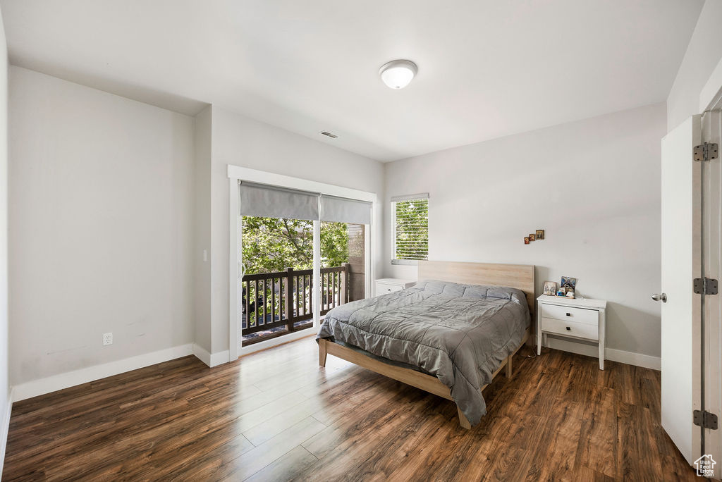 Bedroom with access to exterior and wood finished floors