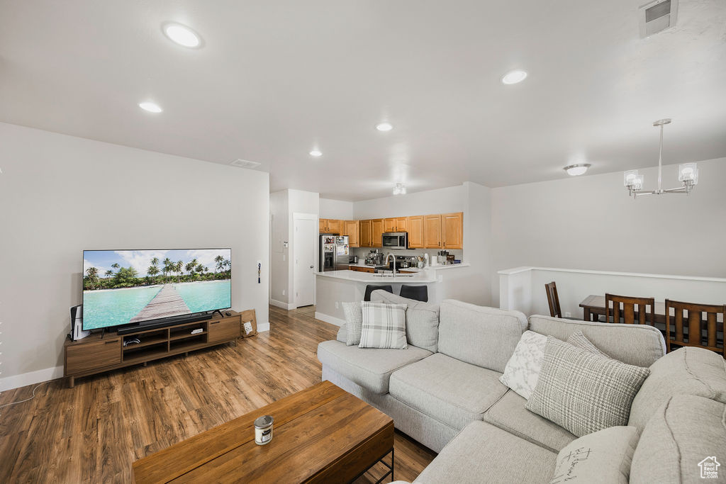 Living area featuring a chandelier, wood finished floors, and recessed lighting