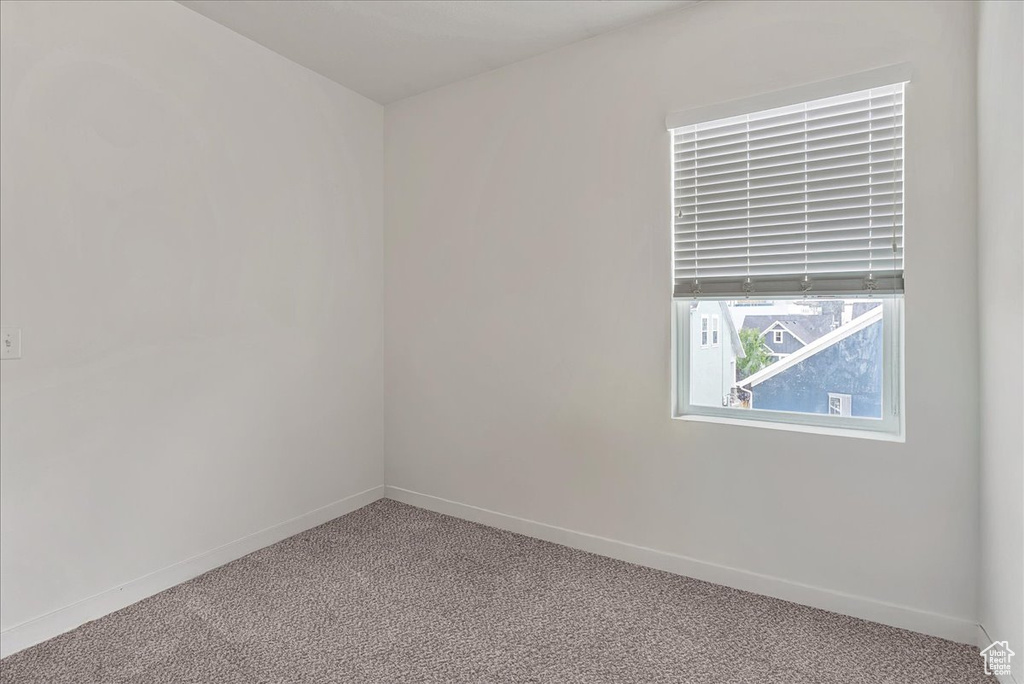 Carpeted empty room with baseboards