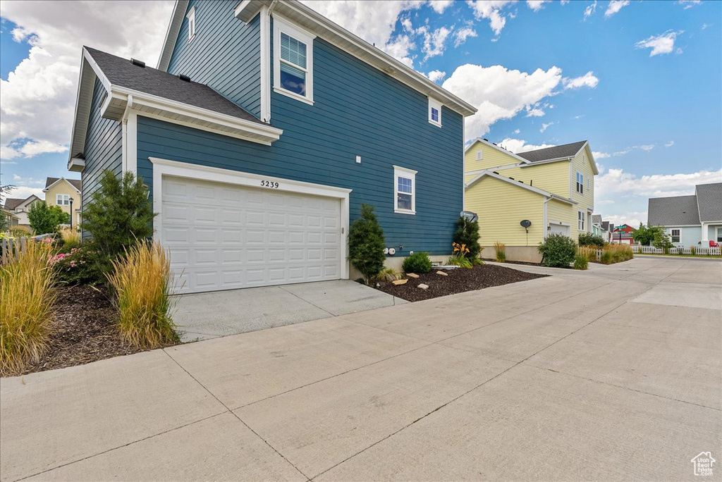 View of side of property with driveway and a residential view