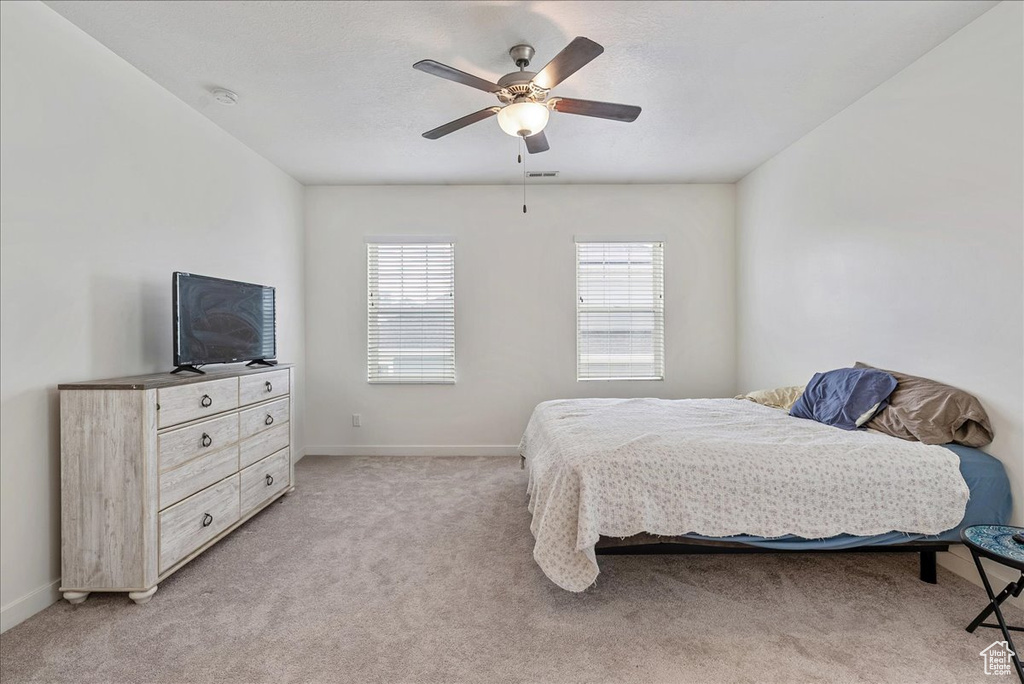 Bedroom featuring light colored carpet and a ceiling fan