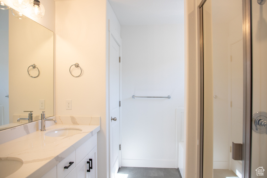 Full bathroom with double vanity and a shower with door