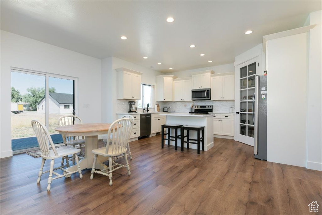 Dining area with dark wood-style flooring and recessed lighting