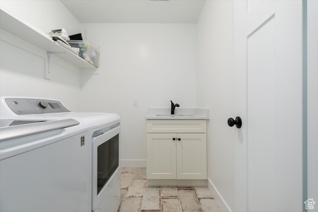 Laundry room featuring washer and clothes dryer and cabinet space